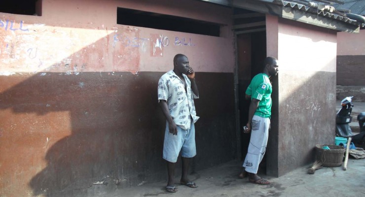 People Awaiting Their Turn at a Public Toilet