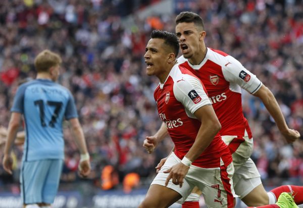 Arsenal's Alexis Sanchez, center, celebrates after scoring his side's second goal during the English FA Cup semifinal soccer match between Arsenal and Manchester City at Wembley stadium in London, Sunday, April 23, 2017. (AP Photo/Kirsty Wigglesworth)